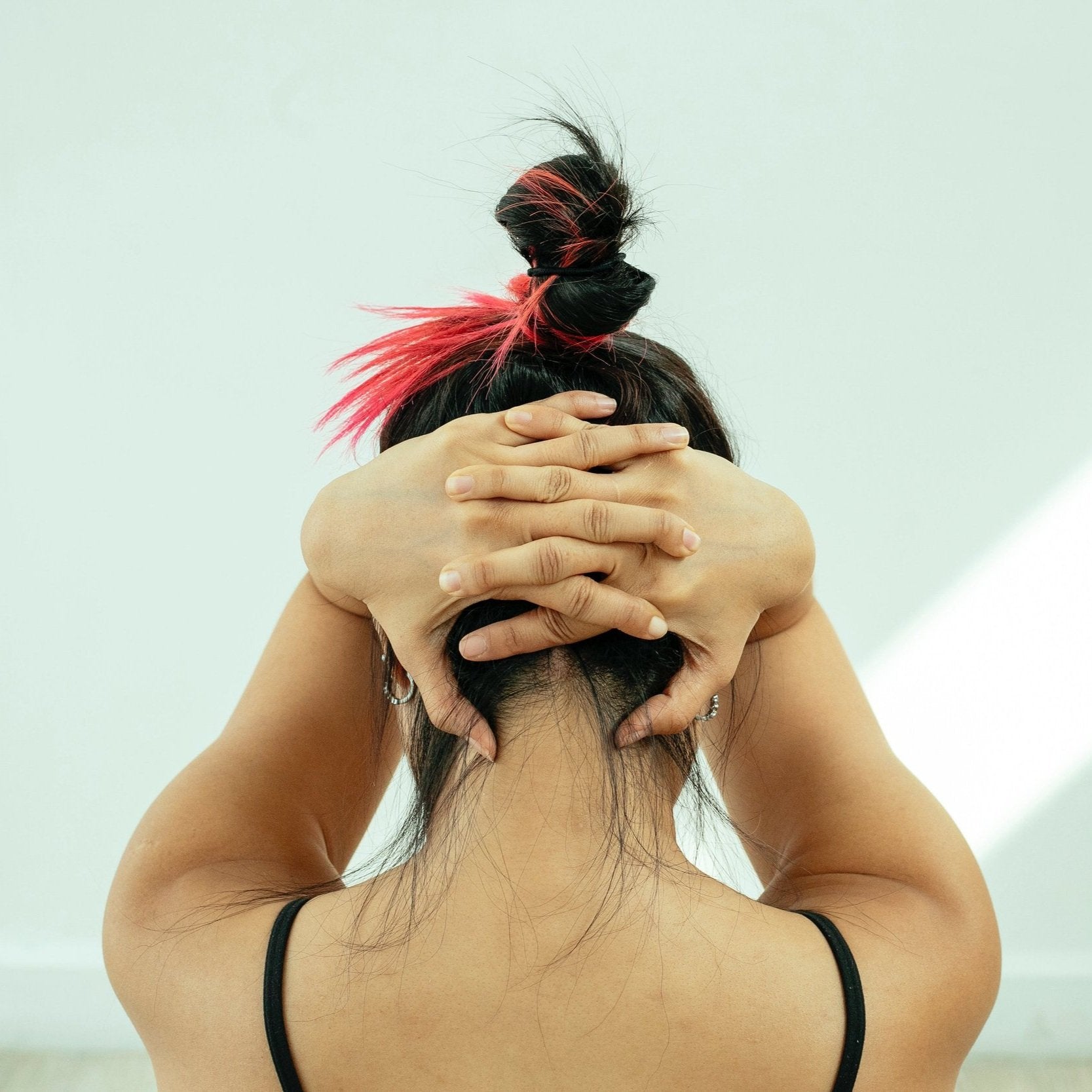 back view of a knitter doing a neck stretch to relieve pain