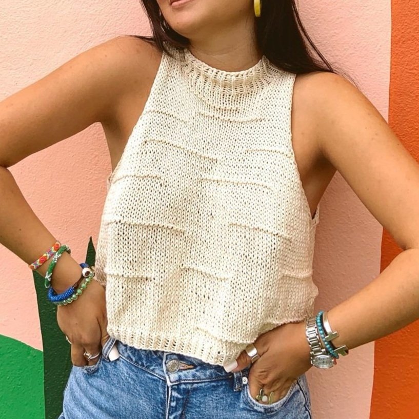 A woman wearing the Snakes and Ladder knitted top pattern during summer time