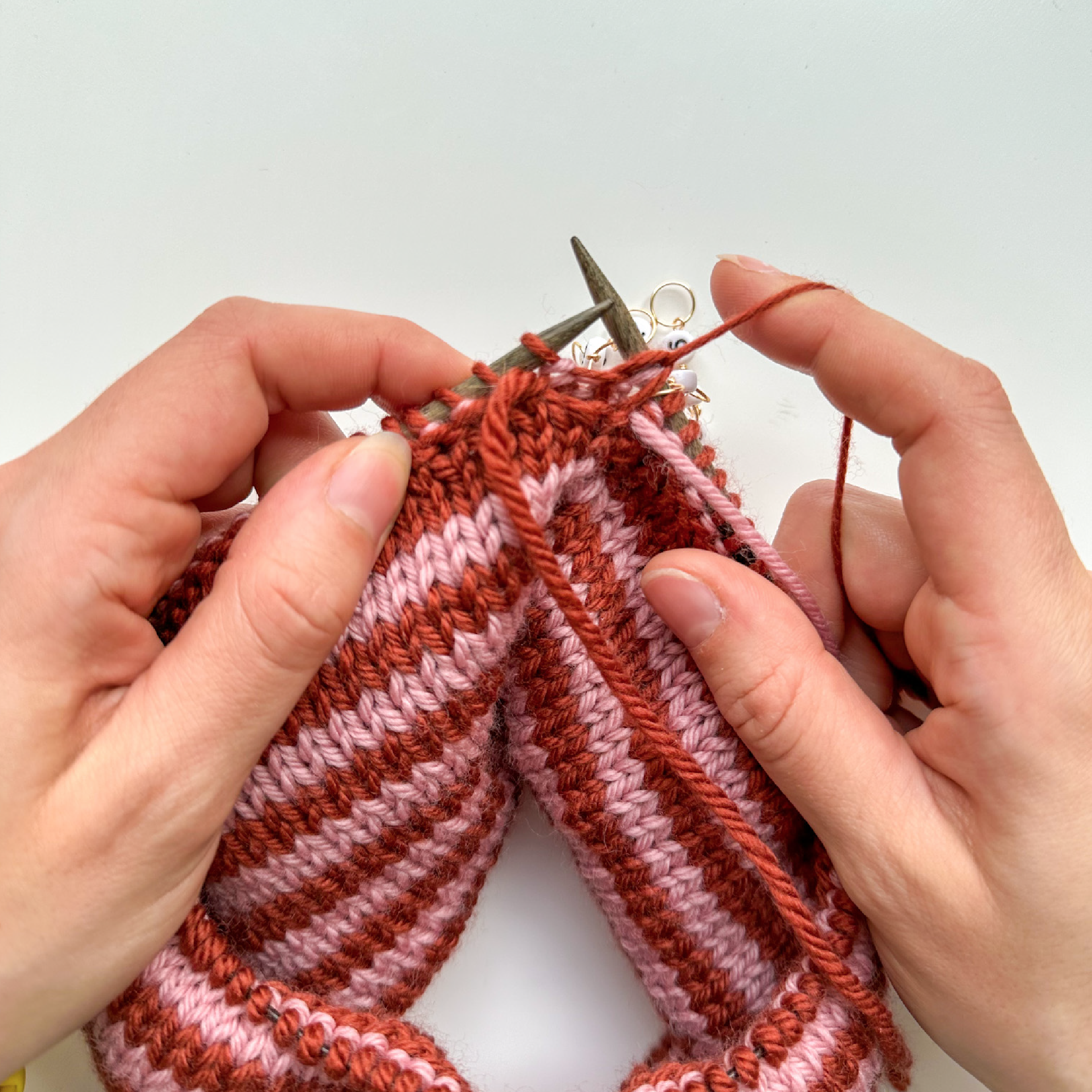 Close-up of German short rows being worked in knitting, showing the wrapped stitches and needle placement
