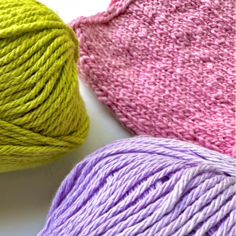 Colorful yarn skeins and a piece of knitted fabric