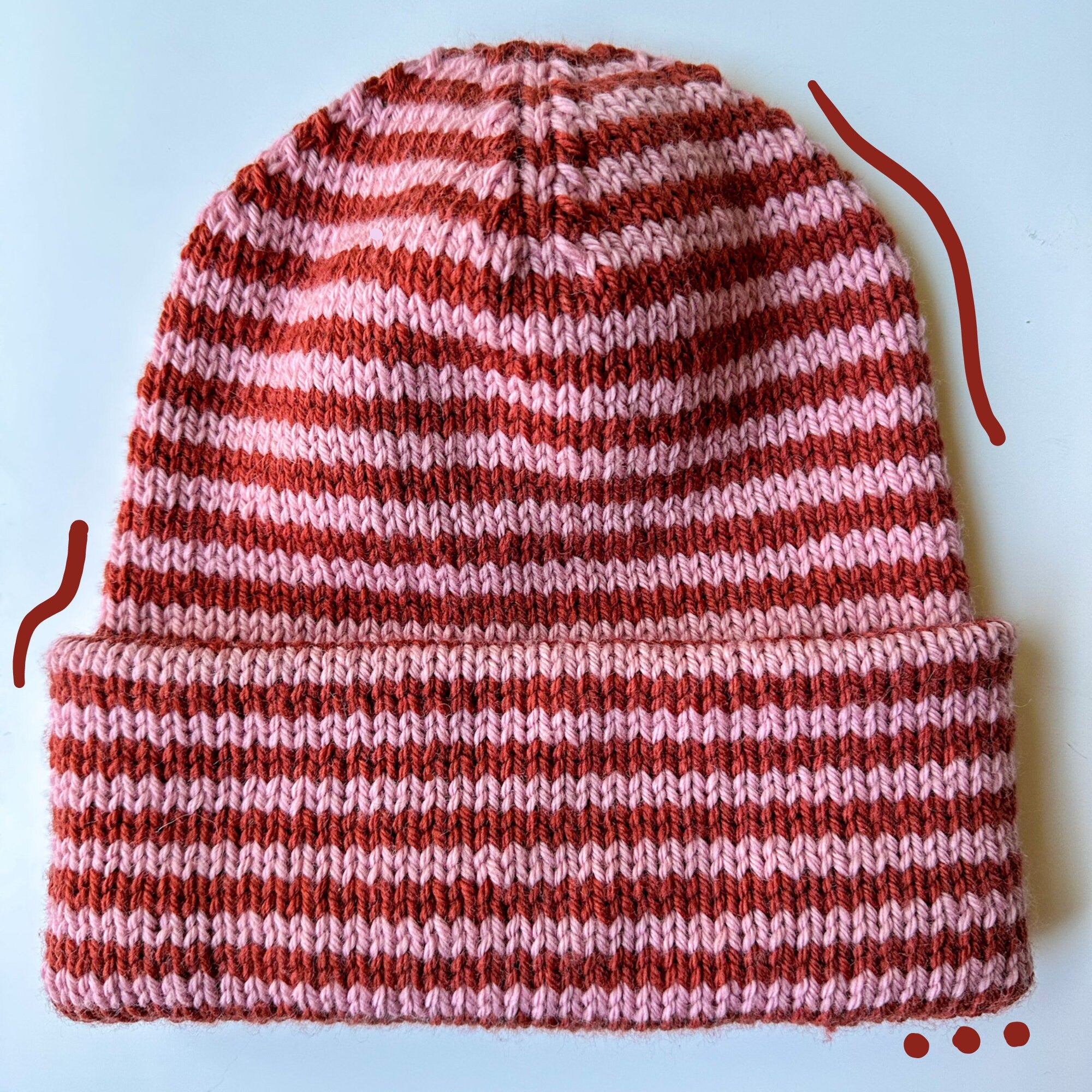 Tall Staple Beanie PDF pattern featuring a red striped knitted hat that highlights its distinctive design.