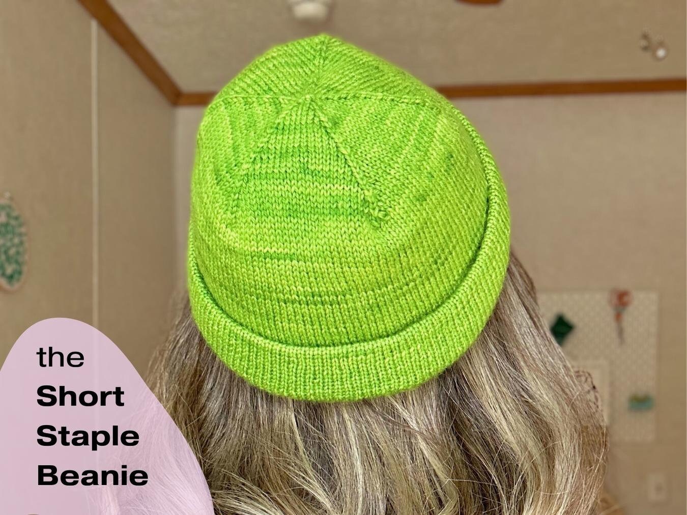 a person wearing a lime green knitted hat using the short staple beanie pattern